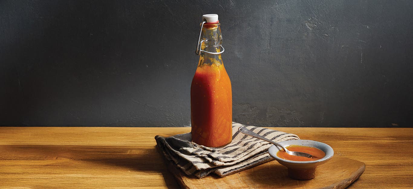 A bottle of Curried Mango Ketchup on a folded kitchen towel